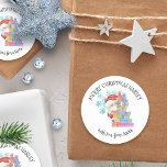 Sticker Rond Personnalisé de Père Noël Kids Christmas Cadeau<br><div class="desc">Des autocollants de Noël personnalisés pour les enfants à l'aquarelle mignonne illustration de Père Noël jetant un oeil sur une pile de cadeaux et décorés de flocons de neige. Le libellé est entièrement modifiable et écrit dans la typographie fantaisiste. Il est actuellement écrit "Joyeux Noël [nom] avec l'amour de Père...</div>
