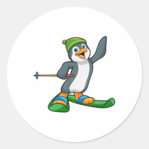 Sticker Rond Pingouin comme skieur avec ski et Casquette