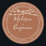 Sticker Rond Rustic Lights TerraCotta Mariage Adresse de retour<br><div class="desc">Mariage moderne et chic, le nom d'adresse de retour avec vos noms en blanc élégant script manuscrit sur un arrière - plan en terre cuite avec une touche élégante de lampes à cordes rustiques de fées. Ajoutez simplement vos noms et votre adresse. Conçu exclusivement pour vous par Happy Dolphin Studio....</div>