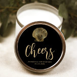 Sticker Rond Salutations Black Gold Coastal Beach Mariage<br><div class="desc">L'illustration vintage d'un coquillage de coquillages de pétoncles orne cet élégant autocollant de mariage de plage côtière,  avec du texte doré sur un arrière - plan noir. Le mot "Cheers" apparaît dans un élégant script d'écriture. Ajoutez les noms du couple et la date du mariage ci-dessous.</div>