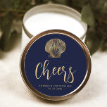 Sticker Rond Salutations Marine Blue Gold Plage Mariage<br><div class="desc">L'illustration vintage d'un coquillage de coquillages décorent cet autocollant de mariage classique de plage côtière,  avec du texte de couleur or sur un arrière - plan bleu marine. Le mot "Cheers" apparaît dans un élégant script d'écriture. Ajoutez les noms du couple et la date du mariage ci-dessous.</div>