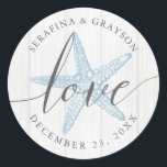 Sticker Rond Starfish Love Rustic Wood Blue Beach Wedding Favor<br><div class="desc">Sticker Rustic Beach Wedding Favor ou Envelope Sceau avec des noms et date mariage et le mot "amour" dans un élégant script de calligraphie écrit à la main sur un arrière - plan en bois gris clair avec illustration de perwinkle bleu vintage étoile de mer.</div>
