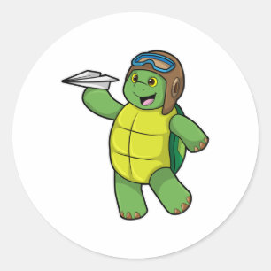 Sticker Rond Tortue comme pilote avec avion en papier