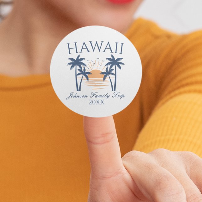 Sticker Rond Voyage en famille Hawaii (Woman holding a Hawaii family trip sticker with a sunset and palm tree design.)