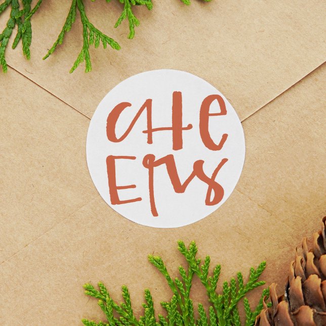 Stickers Vacances Lettrés à la main (Red and white hand-lettered Cheers Christmas round sticker.)