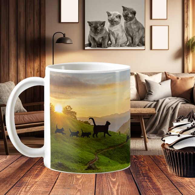 Suivre le Chat Trail Amusant Family Mug (A fun and whimsical mug featuring cat families walking through a hilly landscape at sunset)