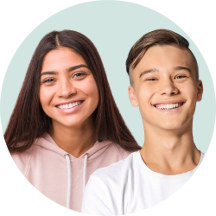 A teen girl and boy against a pastel green background.