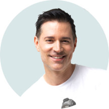 A man against a pastel green background.