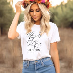 T-shirt calligraphié avec le nom de la future mari<br><div class="desc">Célébrez la future mariée avec ce magnifique t-shirt à calligraphie script comportant "Future mariée" en typographie manuscrite fluide et un prénom personnalisable. Un beau souvenir de monogramme pour les fêtes de fiançailles, les douches de mariée et les week-ends d'enterrement de vie de jeune fille. Modifiez le nom pour personnaliser pour...</div>