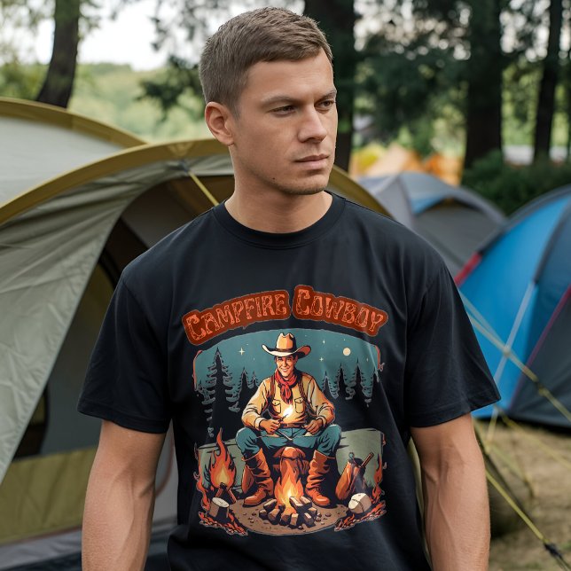 T-shirt Cowboy Western Graphique Rétro de Campement (A man wearing a black t-shirt with a "Campfire Cowboy" graphic design, standing in front of a camp)