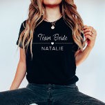 T-shirt Équipe de basket-ball mariée<br><div class="desc">Élevez votre style de soirée de bachelorette avec notre T-shirt mariée personnalisée Team Bride dans une couleur foncée chic et audacieuse, ornée de tirages blancs frappants. Conçues pour la mariée et son équipe, ces chemises de couleur foncée ajoutent une touche de sophistication à votre célébration tout en maintenant un sentiment...</div>