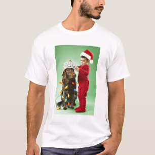 T-shirt Jeune garçon enroulant des lumières de Noël autour