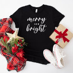 T-shirt Joyeux et lumineux Noël des femmes noires modernes<br><div class="desc">Un tee-shirt graphique festif pour les femmes avec une typographie en minuscules moderne avec "Joyeux et brillant". Le texte blanc et le style de chemise noire peuvent tous deux être modifiés.</div>