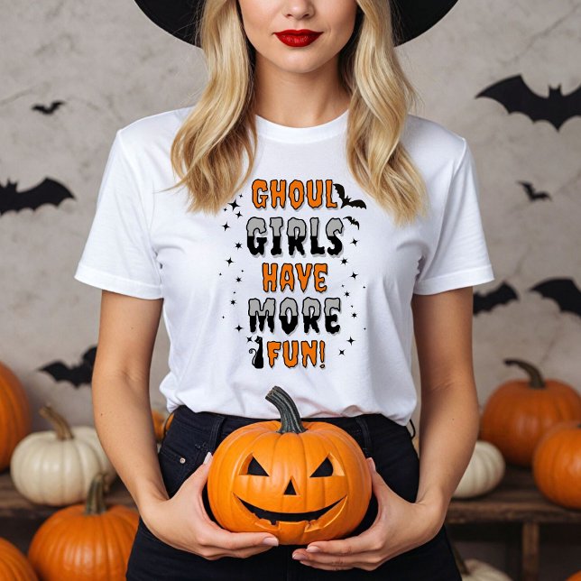 T-shirt Les Filles Ghoul Ont Plus Amusant Halloween Modern (Women in a white Ghoul Girls have more fun shirt with Halloween decor.)