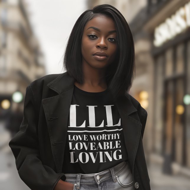 T-shirt LLL- Amour Digne, Amoureux, Amoureux (Young African American woman wears a black shirt that reads "LLL: Love Worthy, Loveable, Loving.")