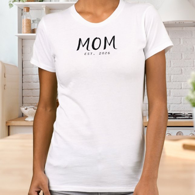 T-shirt Police Script Maman Établie (A white t-shirt with "Mom Est. 2026" design in black lettering)