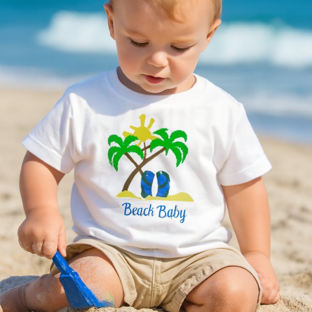 T-shirt Pour Bébé Bébé mignon de la plage  (a toddler playing in the sand with a small blue shovel, wearing a white crewneck short-sleeve tee-)
