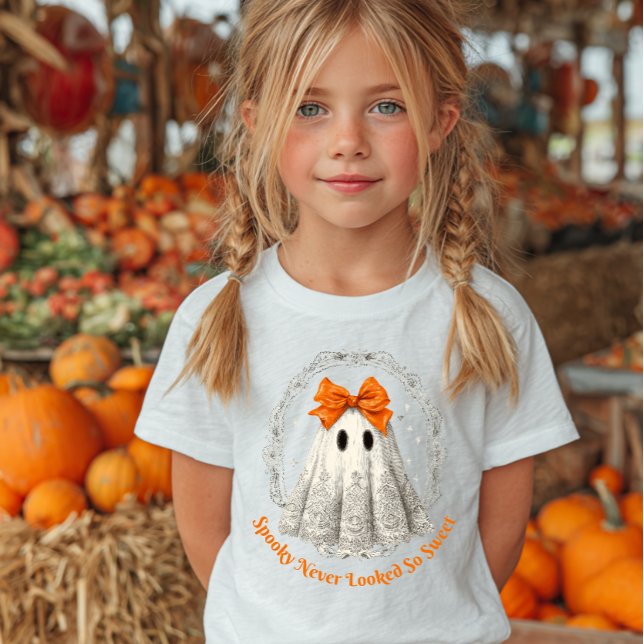 T-shirt Pour Bébé Lace Ghost with Bow in Wreath and Stars (Young girl with blonde pigtails wearing a Halloween-themed T-shirt featuring a cute ghost.)