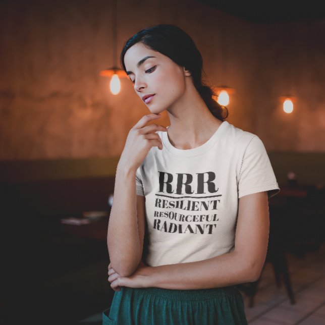 T-shirt RRR - Résistant, ingénieux, radiant (Young woman in thoughtful pose wearing a "RRR: Relilient, Resourceful, Radiant" white t-shirt.)