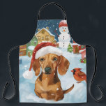 Tablier Dachshund Winter Wonderland Christmas Joy<br><div class="desc">Ce design festif reflète l'esprit joyeux de la période des fêtes, avec un adorable petit portant un chapeau de Père Noël. Le chien est niché dans un pays des merveilles hivernales, avec un bonhomme de neige, un sapin de Noël décoré et des cadeaux joliment emballés. Les flocons de neige tombent...</div>
