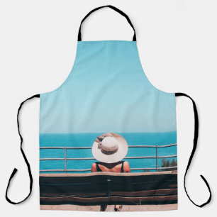 Tablier Femme en paille blanche casquette assise sur un ba