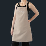 Tablier Modèle moderne beige tanné personnalisé nom uni<br><div class="desc">Personnalisé beige tan neutre personnalisé nom de script moderne texte monogramme solide couleur unie girly élégant chic beige tan neutre et blanc cuisine Apron. Texte blanc personnalisé sur un arrière - plan beige clair et solide. Customisez, personnalisez-le avec le nom, le devis, l'expression ou le texte. Idéal pour cuisiniers, chefs,...</div>