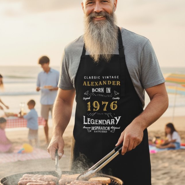 Tablier "Né en 1976" Grill Master Apron for Men (Man wearing a personalized apron while BBQ'ing at a beach )