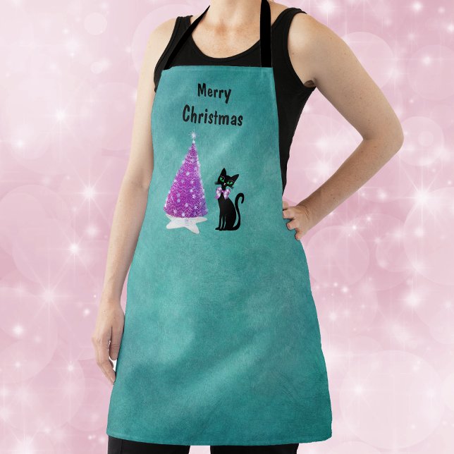 Tablier Noël Rose Arbre Argent Étoile Tapis Chat Noir Sarc (Pink silver tree on star rug with black cat wearing pink bow on teal Christmas kitchen apron.)