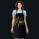 Tablier Nom du salon de coiffure en noir et or<br><div class="desc">Salon de coiffure en noir et or Nom tablier noir. Caractéristiques de la conception Calligraphie ''Hair''' en couleur or sur un arrière - plan noir. Personnaliser avec un nom ou un nom de salon.</div>
