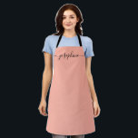 Tablier Nom du script élégant tendance Fuzzy Peach<br><div class="desc">Elle va adorer un tablier personnalisé en cuisinant ces bonbons,  en cuisinant de délicieux plats ou en travaillant avec ses plantes. Un cadeau parfait pour encourager ses talents. Script noir pour le nom avec des embellissements à queue longue. Couleur Fou Peach.</div>
