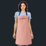 Tablier Nom du script élégant tendance Fuzzy Peach<br><div class="desc">Elle va adorer un tablier personnalisé en cuisinant ces bonbons,  en cuisinant de délicieux plats ou en travaillant avec ses plantes. Un cadeau parfait pour encourager ses talents. Script noir pour le nom avec des embellissements à queue longue. Couleur Fou Peach.</div>
