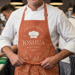 Tablier Vintage Kitchen Chef Cooking Utensil Pattern<br><div class="desc">This design features a warm terracotta background with a vintage-style chef layout, including a chef hat emblem, curved kitchen text, and a scattered pattern of cooking utensils and ingredients. The hand-drawn line art of rolling pins, pans, spoons, knives, tomatoes, and lemons gives it a playful yet classic culinary feel. Its...</div>