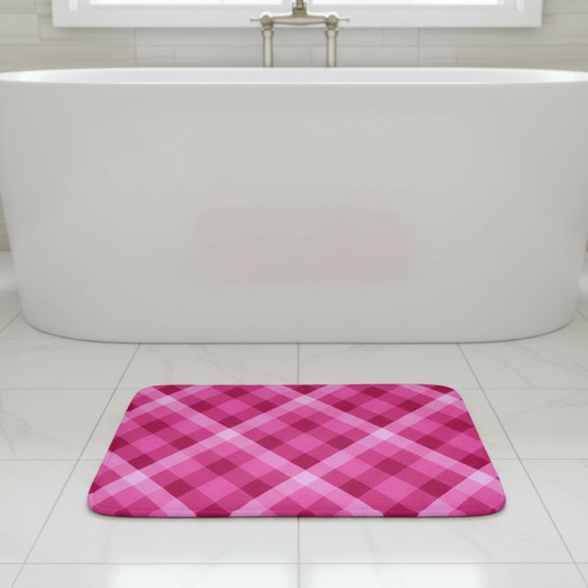Tapis de bain petit format à carreaux magenta rose (Beautiful Pink Magenta Plaid Small Bath Mat laying flat on tile floor in front of tub in bathroom.)