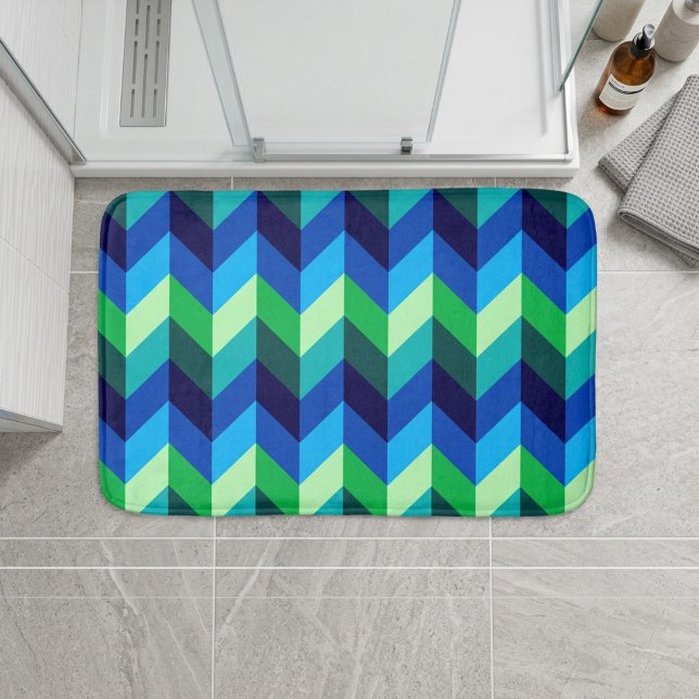 Tapis de bain petit format ombré bleu-vert à chevr (Blue Green Ombre Chevrons Small Bath Mat on floor in front of shower in a modern style bathroom.)