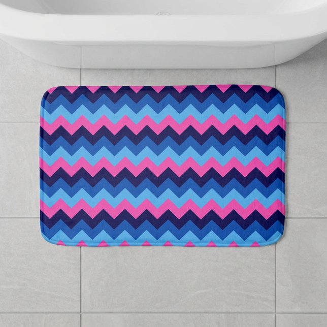 Tapis de bain petit modèle à motif chevron rose bl (Cool Blue Pink Chevron Pattern Small Bath Mat laying on floor in front of tub in a bathroom.)