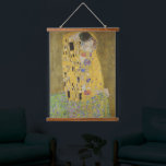 Tapisserie Suspendue Gustav Klimt-Le Baiser | Oeuvre Gold Leaf<br><div class="desc">Le "Baiser" de Gustav Klimt est sans aucun doute l'un des tableaux les plus iconiques et vénérés du début du XXe siècle, incarnant le mouvement Art Nouveau avec ses détails complexes et ses accents de feuilles d'or. L'oeuvre représente un couple aimant, un homme et une femme, enfermé dans un baiser...</div>