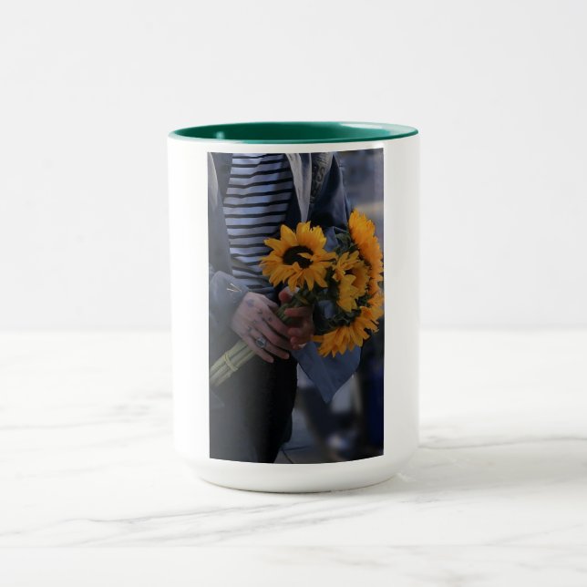 Tasse blanche où une main tient des tournesols ave (Centre)