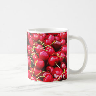 Tasse rouge lumineuse de photo de cerises