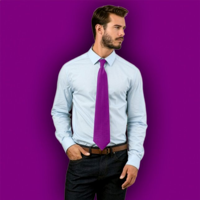Tie  violet uni -  cravate d'une seule couleur (Man wearing a solid purple necktie, standing against a purple background that matches the tie.
)