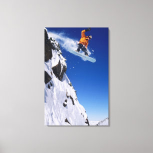 Toile Homme sur un snowboard sautant d'une corniche à