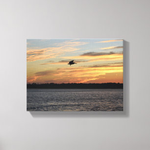 Toile Silhouette de pélican survolant la rivière