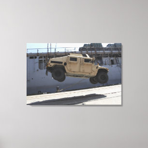 Toile Une grue monte un M998 Humvee