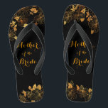 Tongs Mère de la mariée Black & Gold Foliage Motif<br><div class="desc">Ces flip flops de feuillage noir et or de la Mère de la Mariée se vantent d'une luxueuse palette de noir et or, avec un superbe motif floral doré et une typographie moderne dressée contre un arrière - plan noir, exsudant élégance et sophistication. C'est un beau cadeau pour votre fête...</div>