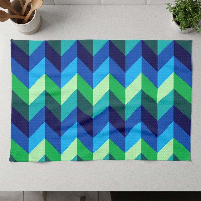 Torchon de cuisine chevrons ombrés bleu vert (Blue Green Ombre Chevrons Kitchen Towel lying on a counter top in a modern style kitchen.)