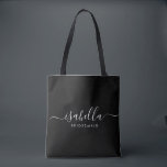 Tote Bag Cadeau Bridesmaid personnalisé noir<br><div class="desc">Ce sac d'accessoires Bridesmaid comporte une typographie manuscrite en écriture blanche avec des swashes sur un arrière - plan noir. Présentez un sac fourre-tout à vos serveuses d'accueil pour les petits articles traditionnellement présentés au dîner de répétition,  à utiliser tôt le matin avant le mariage.</div>