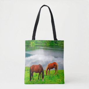 Tote Bag Chevaux pâturant prairie avec un lac de forêt