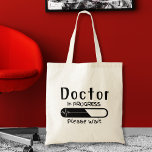 Tote Bag Docteur en cours Veuillez patienter<br><div class="desc">Entrez dans le domaine de la médecine avec confiance et style avec notre sac fourre-tout "Doctor in Progress : Please Wait". Conçu avec l'étudiant en médecine ou aspirant médecin en tête, ce sac fourre-tout sert d'accessoire pratique pour transporter vos essentiels tout en faisant une déclaration sur votre voyage en médecine...</div>