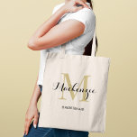 Tote Bag Élégante Demoiselle d'Honneur Monogramme Or Noir<br><div class="desc">Le glamour intemporel rencontre l'élégance classique avec ce fourre-tout présentant une initiale monogramme dorée superposée d'un nom personnalisé en écriture noire sophistiquée et le rôle dans le cortège de mariage en dessous. Un souvenir de monogramme luxueux avec une chaude lueur dorée qui élève toute célébration de mariage. Le nom, l'initiale...</div>