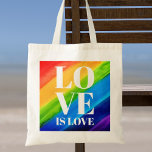 Tote Bag L'amour est la fierté de l'amour<br><div class="desc">Ce Sac fourre-tout Pride est décoré avec LOVE IS LOVE en caractères blancs gras sur un arc-en-ciel d'aquarelle arrière - plan de rouge,  orange,  jaune,  vert,  bleu et violet. Aquarelle originale © Michele Davies.</div>