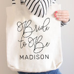 Tote Bag Mariée à être noir Script moderne mariage personna<br><div class="desc">Scénario de calligraphie noire chic et moderne "Mariée à être" sac fourre-tout de mariages mariées avec un texte personnalisé qui peut être personnalisé avec le prénom de la mariée. Accessoire parfait pour la soirée bachelorette et le week-end mariage !</div>